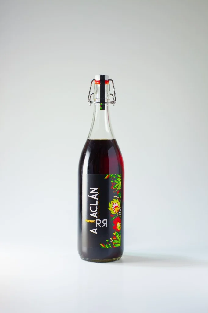 Botella de Vermut Arraclán con tapón mecánico, etiqueta negra con leyenda Arraclán artesano de la Vera, Vermut Rojo y motivos florales