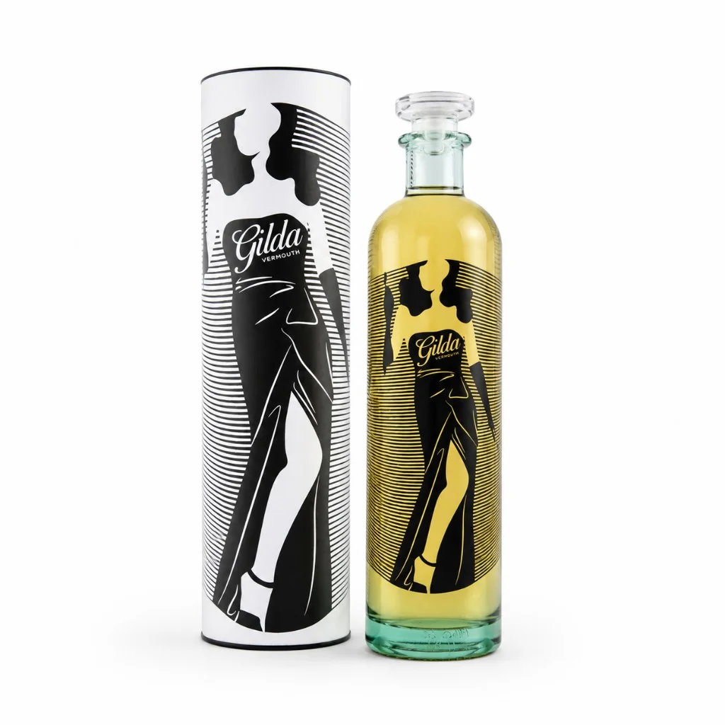 Botella de Vermut Gilda Blanco con estuche cilíndrico blanco, silueta de Gilda y leyenda Gilda Vermouth