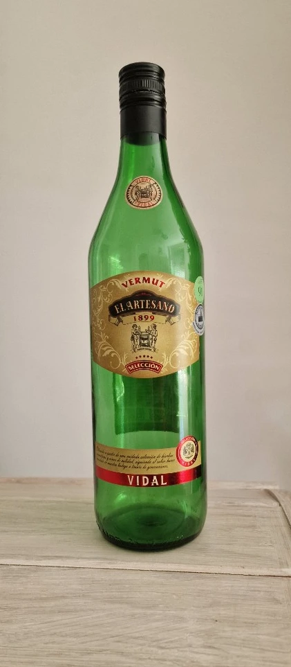 Botella de Vermouth El Artesano 1899 de Bodegas Vidal, vidrio verde con etiqueta dorada y franja roja
